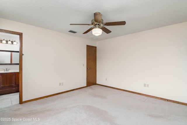 1262 Heberling St NW, Palm Bay, FL 32907 - spare room with light carpet, a sink, a ceiling fan, and baseboards
