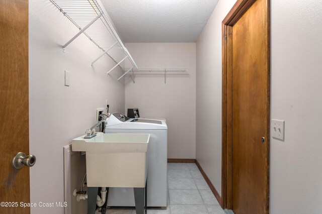 1262 Heberling St NW, Palm Bay, FL 32907 - laundry area featuring washer and clothes dryer, light tile patterned flooring, and baseboards