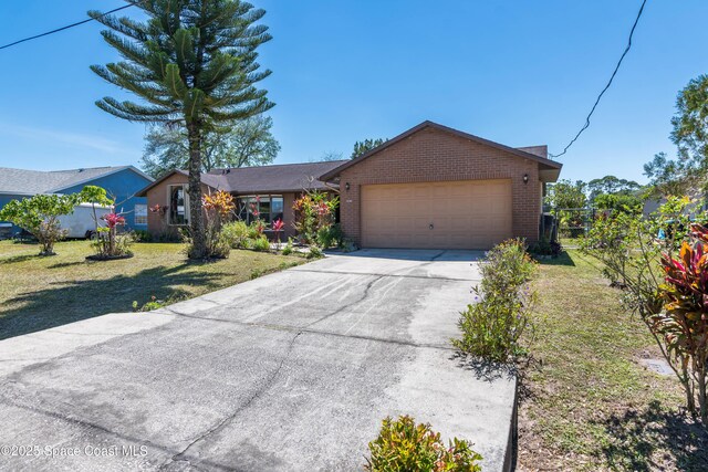 1262 Heberling St NW, Palm Bay, FL 32907 - single story home with brick siding, an attached garage, and driveway