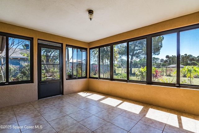 1262 Heberling St NW, Palm Bay, FL 32907 - unfurnished sunroom with a textured wall, healthy amount of natural light, and tile patterned floors