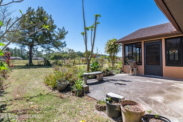 1262 Heberling St NW, Palm Bay, FL 32907 - view of grassy yard with a patio and a sunroom