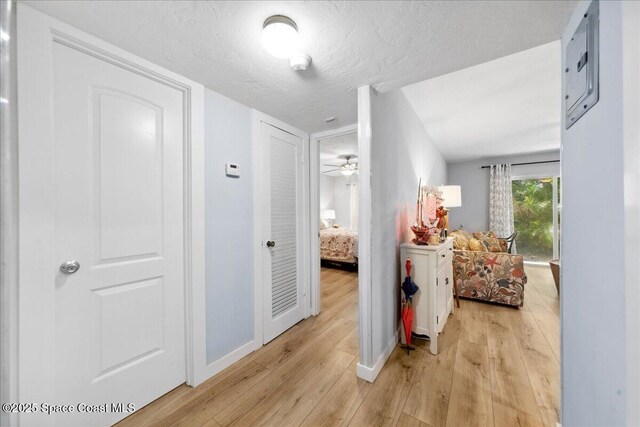 221 Columbia Dr Unit 139, Cape Canaveral, FL 32920 - hall featuring light wood-style flooring, baseboards, and a textured ceiling