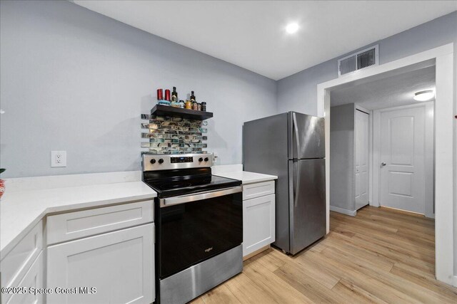 221 Columbia Dr Unit 139, Cape Canaveral, FL 32920 - kitchen featuring stainless steel electric range oven, freestanding refrigerator, light wood-style flooring, white cabinets, and light countertops