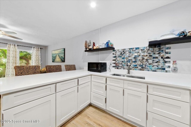 221 Columbia Dr Unit 139, Cape Canaveral, FL 32920 - kitchen featuring a sink, black microwave, light countertops, open shelves, and a ceiling fan