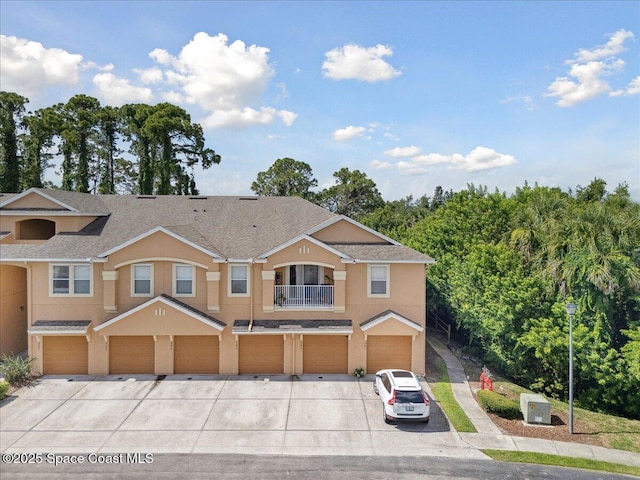 4047 Meander Pl Unit 208, Rockledge, FL 32955 - townhome / multi-family property with driveway, stucco siding, a garage, a balcony, and roof with shingles
