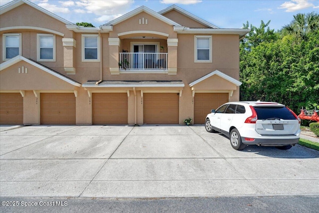 4047 Meander Pl Unit 208, Rockledge, FL 32955 - view of property with stucco siding, driveway, a balcony, and an attached garage