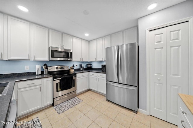 4047 Meander Pl Unit 208, Rockledge, FL 32955 - kitchen with appliances with stainless steel finishes, recessed lighting, light tile patterned flooring, white cabinetry, and dark countertops
