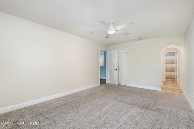 2111 Spring Creek Cir, Palm Bay, FL 32905 - unfurnished room featuring arched walkways, ceiling fan, light colored carpet, and baseboards