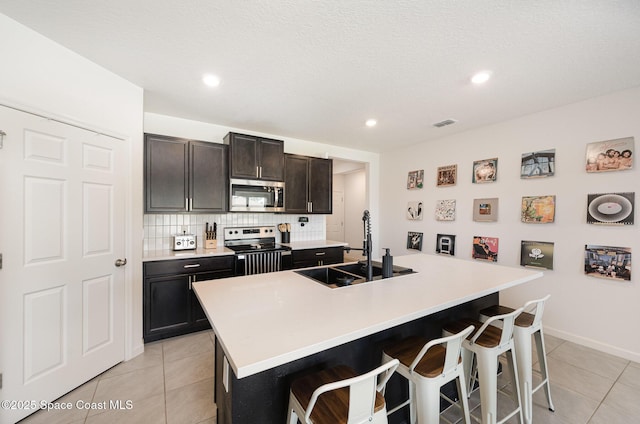 4791 Talbot Blvd, Cocoa, FL 32926 - kitchen featuring appliances with stainless steel finishes, a breakfast bar, light tile patterned flooring, tasteful backsplash, and recessed lighting