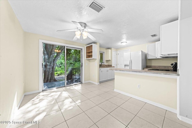 501 Santo Domingo Ave SW, Palm Bay, FL 32908 - kitchen with white fridge with ice dispenser, under cabinet range hood, a peninsula, a ceiling fan, and white cabinetry