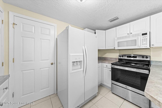 501 Santo Domingo Ave SW, Palm Bay, FL 32908 - kitchen with white appliances, light tile patterned flooring, white cabinets, light countertops, and a textured ceiling