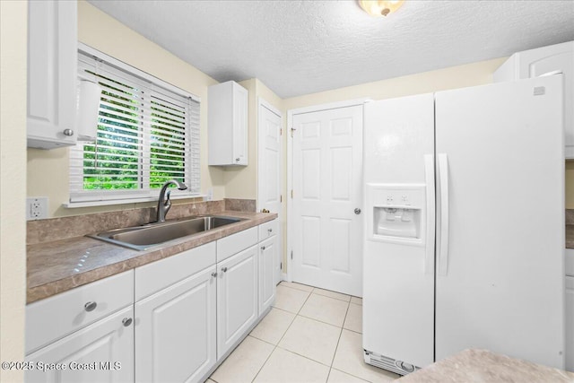 501 Santo Domingo Ave SW, Palm Bay, FL 32908 - kitchen with white refrigerator with ice dispenser, white cabinets, light tile patterned flooring, and a textured ceiling