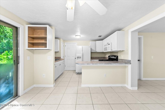 501 Santo Domingo Ave SW, Palm Bay, FL 32908 - kitchen featuring white appliances, a peninsula, light tile patterned floors, a textured ceiling, and white cabinets