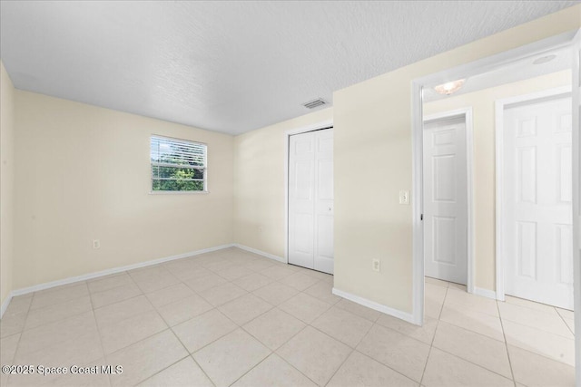 501 Santo Domingo Ave SW, Palm Bay, FL 32908 - unfurnished bedroom featuring a textured ceiling, light tile patterned floors, and a closet
