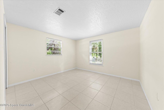 501 Santo Domingo Ave SW, Palm Bay, FL 32908 - empty room with plenty of natural light, a textured ceiling, and light tile patterned flooring