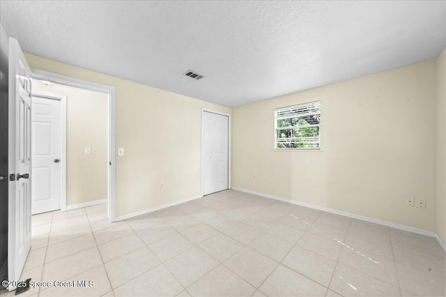 501 Santo Domingo Ave SW, Palm Bay, FL 32908 - unfurnished bedroom with light tile patterned flooring, a textured ceiling, and a closet