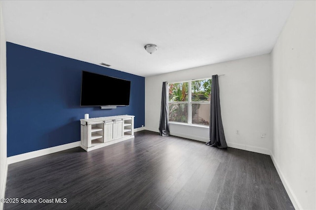 6735 Grissom Pkwy, Cocoa, FL 32927 - unfurnished living room featuring dark wood-type flooring and baseboards