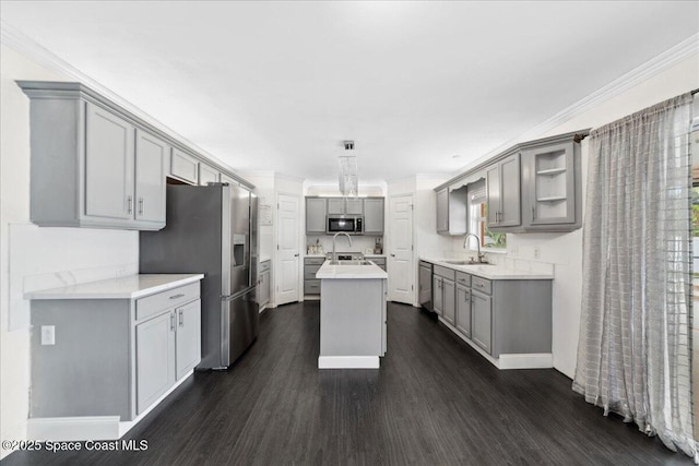 6735 Grissom Pkwy, Cocoa, FL 32927 - kitchen featuring gray cabinets, stainless steel appliances, a sink, dark wood-style flooring, and a center island with sink