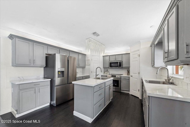 6735 Grissom Pkwy, Cocoa, FL 32927 - kitchen featuring stainless steel appliances, gray cabinetry, a sink, a kitchen island with sink, and ornamental molding