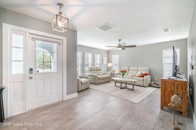 1237 Glenham Dr NE, Palm Bay, FL 32905 - living area featuring ceiling fan, light wood-style floors, and baseboards