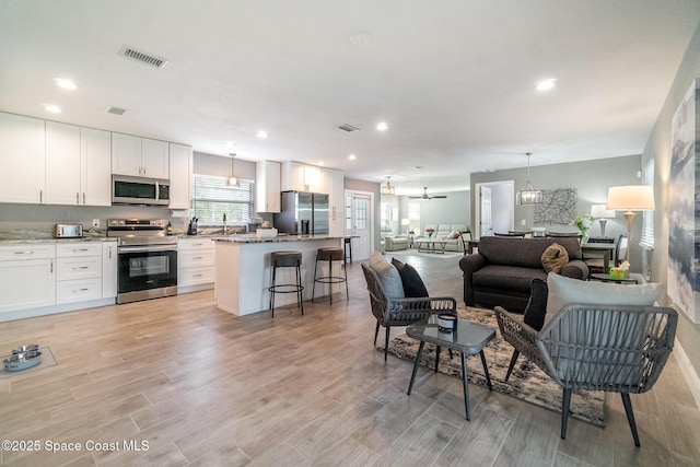 1237 Glenham Dr NE, Palm Bay, FL 32905 - living room with light wood-style floors, recessed lighting, and a chandelier