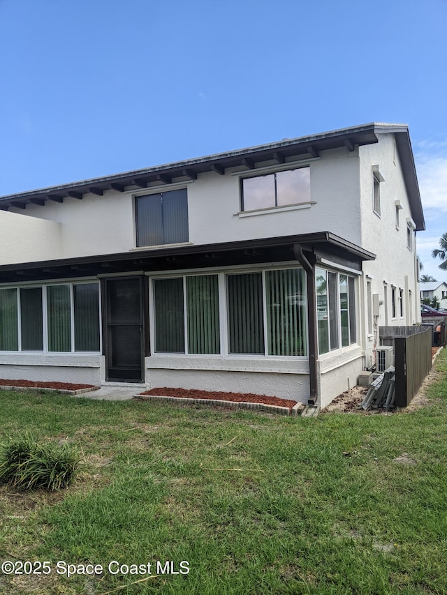 199 Skyline Ct, Satellite Beach, FL 32937 - back of house with stucco siding, a yard, and central AC