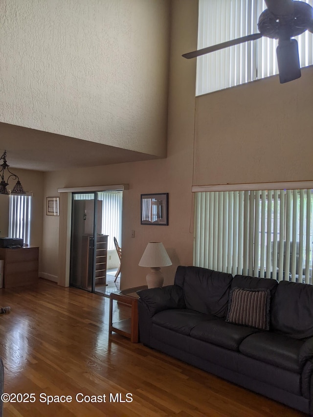 199 Skyline Ct, Satellite Beach, FL 32937 - living room featuring a high ceiling, wood finished floors, and baseboards