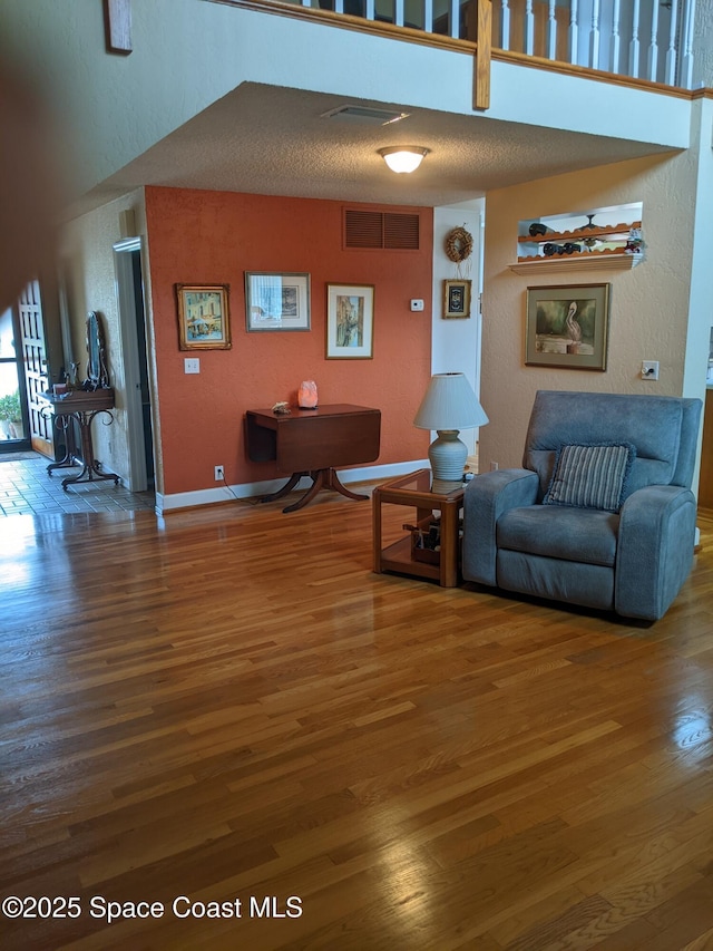 199 Skyline Ct, Satellite Beach, FL 32937 - living room with wood finished floors, a textured wall, and baseboards