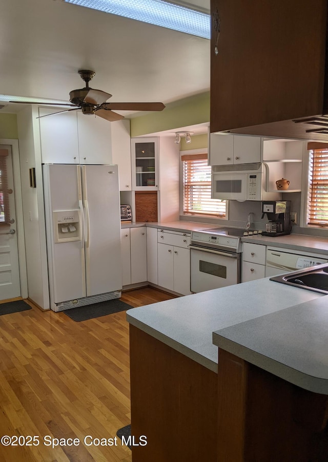 199 Skyline Ct, Satellite Beach, FL 32937 - kitchen with white appliances, white cabinetry, healthy amount of natural light, and light wood finished floors