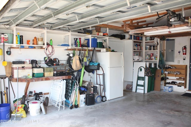199 Skyline Ct, Satellite Beach, FL 32937 - garage featuring freestanding refrigerator, electric panel, a garage door opener, and a workshop area