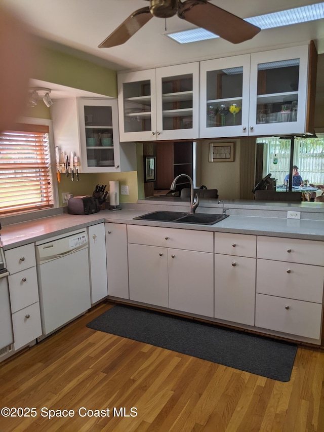 199 Skyline Ct, Satellite Beach, FL 32937 - kitchen with dishwasher, a sink, a ceiling fan, white cabinetry, and light wood finished floors