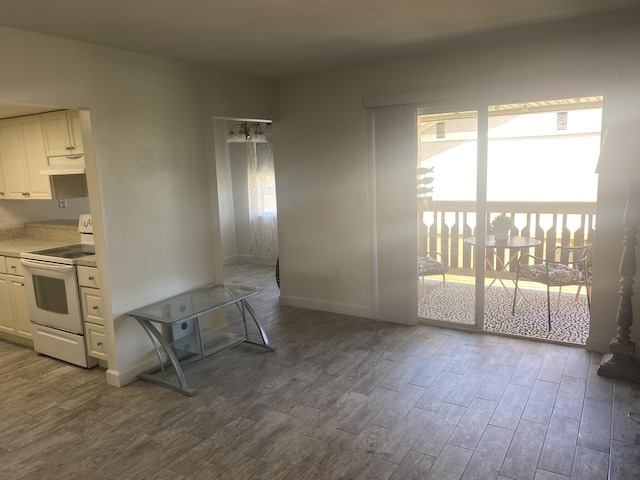231 Bristol Ct Unit 231, Melbourne, FL 32935 - kitchen featuring electric range, dark wood-style flooring, baseboards, and white cabinetry