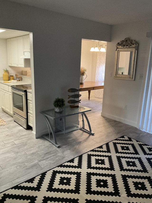 231 Bristol Ct Unit 231, Melbourne, FL 32935 - hallway with light wood-style flooring, a chandelier, and baseboards