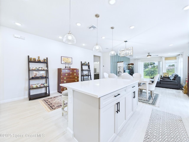 3466 Rixford Way, Palm Bay, FL 32909 - kitchen featuring recessed lighting, white cabinets, light countertops, open floor plan, and a kitchen island