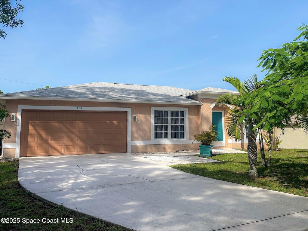 1726 Loquat Ct NW, Palm Bay, FL 32907 - ranch-style house with stucco siding, driveway, an attached garage, and roof with shingles