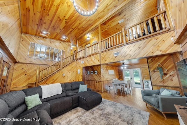 3373 Stratos Ln, Palm Bay, FL 32909 - living room featuring wooden walls, a high ceiling, stairs, wood ceiling, and wood finished floors