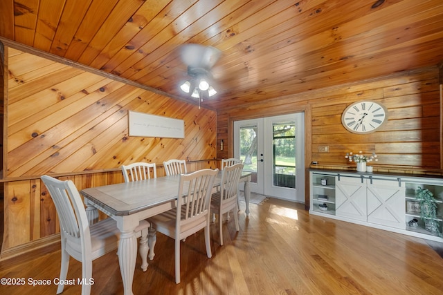 3373 Stratos Ln, Palm Bay, FL 32909 - dining space with wood ceiling, wood walls, a ceiling fan, french doors, and light wood-style floors