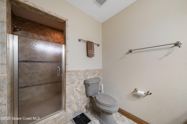 3373 Stratos Ln, Palm Bay, FL 32909 - full bath featuring a shower stall, tile patterned flooring, toilet, tile walls, and wainscoting