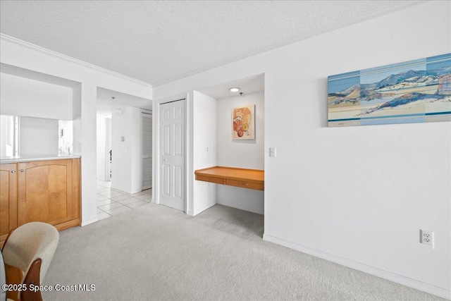 660 S Brevard Ave Unit 1535, Cocoa Beach, FL 32931 - unfurnished bedroom featuring light carpet, a closet, a textured ceiling, and crown molding