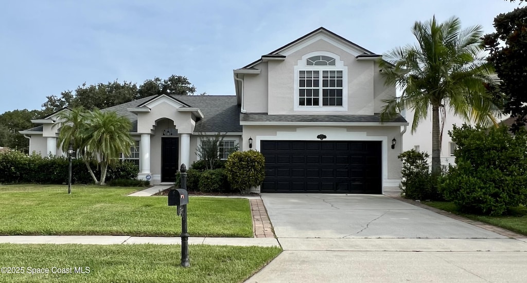 310 Chennault Ln, Rockledge, FL 32955 - view of front of home with stucco siding, a garage, a front yard, concrete driveway, and a shingled roof