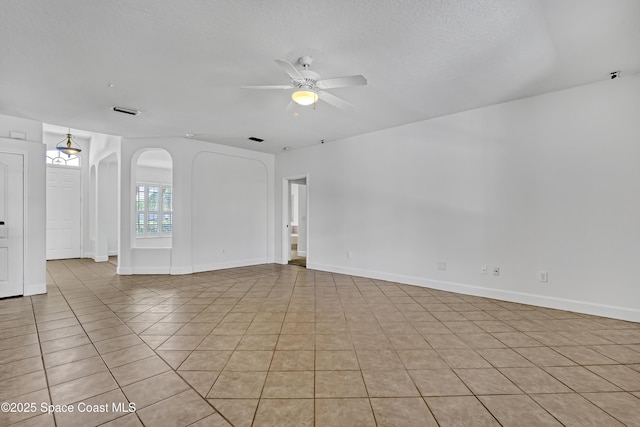 310 Chennault Ln, Rockledge, FL 32955 - spare room featuring arched walkways, a ceiling fan, and light tile patterned floors