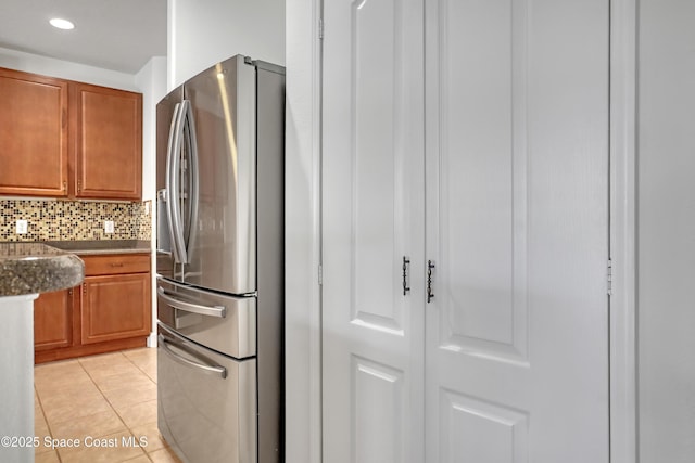310 Chennault Ln, Rockledge, FL 32955 - kitchen with stainless steel fridge with ice dispenser, light tile patterned floors, decorative backsplash, brown cabinets, and recessed lighting