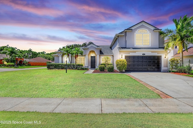 310 Chennault Ln, Rockledge, FL 32955 - view of front of home featuring an attached garage, stucco siding, concrete driveway, and a yard