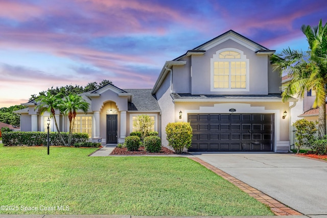 310 Chennault Ln, Rockledge, FL 32955 - view of front facade with a garage, a lawn, concrete driveway, and stucco siding