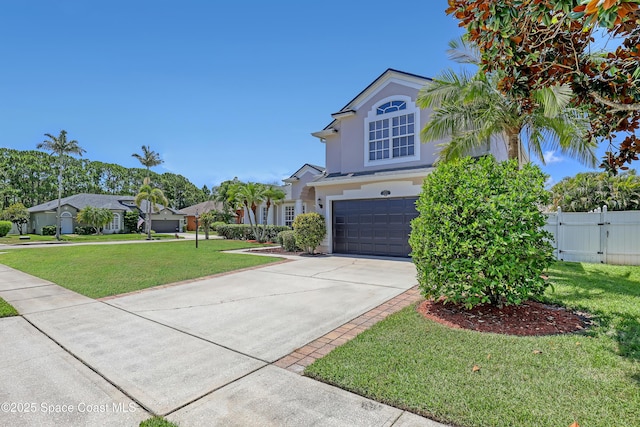 310 Chennault Ln, Rockledge, FL 32955 - view of front of house with stucco siding, a garage, concrete driveway, and a gate