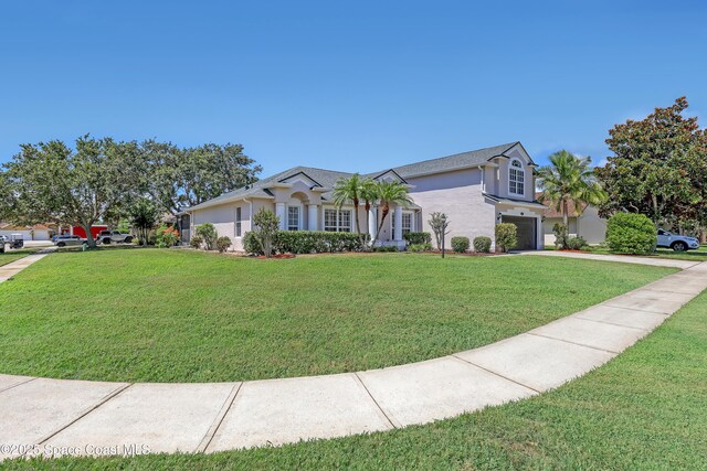 310 Chennault Ln, Rockledge, FL 32955 - single story home featuring a garage, stucco siding, a front lawn, and concrete driveway