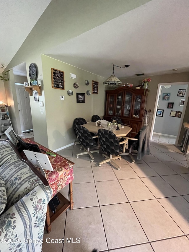 237 Jacaranda Ave NW, Palm Bay, FL 32907 - dining area with light tile patterned floors, lofted ceiling, and baseboards