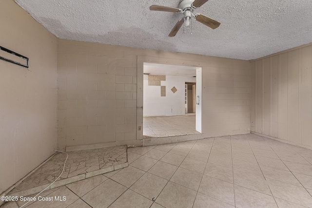 3774 Brockington Cir, Cocoa, FL 32926 - tiled empty room featuring ceiling fan, concrete block wall, and a textured ceiling