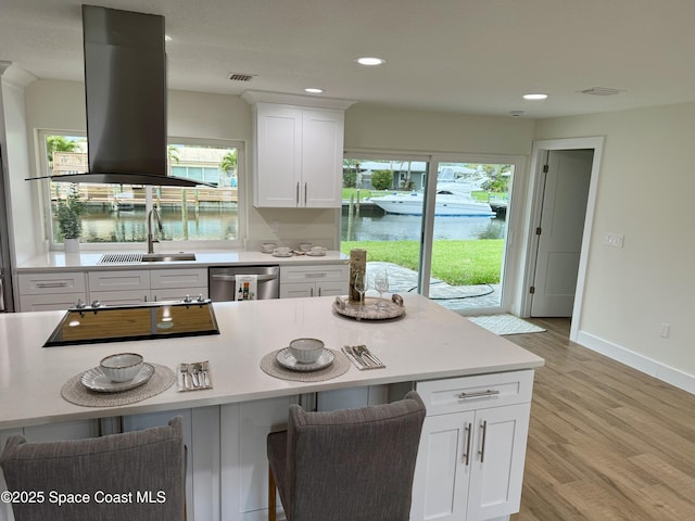57 Riverview Ln, Cocoa Beach, FL 32931 - kitchen with stainless steel dishwasher, island range hood, a sink, a kitchen breakfast bar, and light countertops