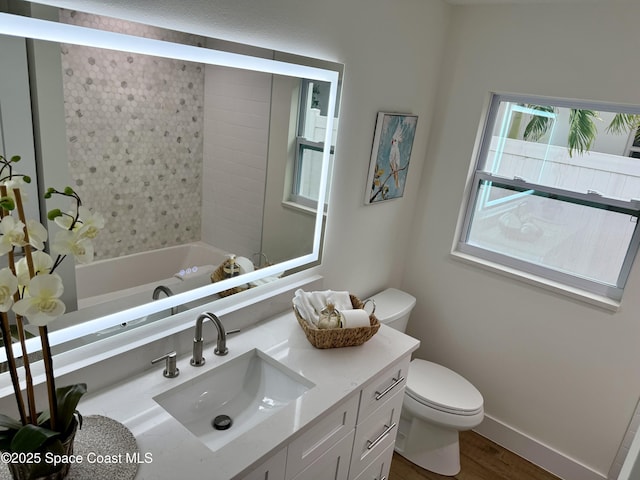 57 Riverview Ln, Cocoa Beach, FL 32931 - full bathroom with vanity, toilet, wood finished floors, baseboards, and tub / shower combination